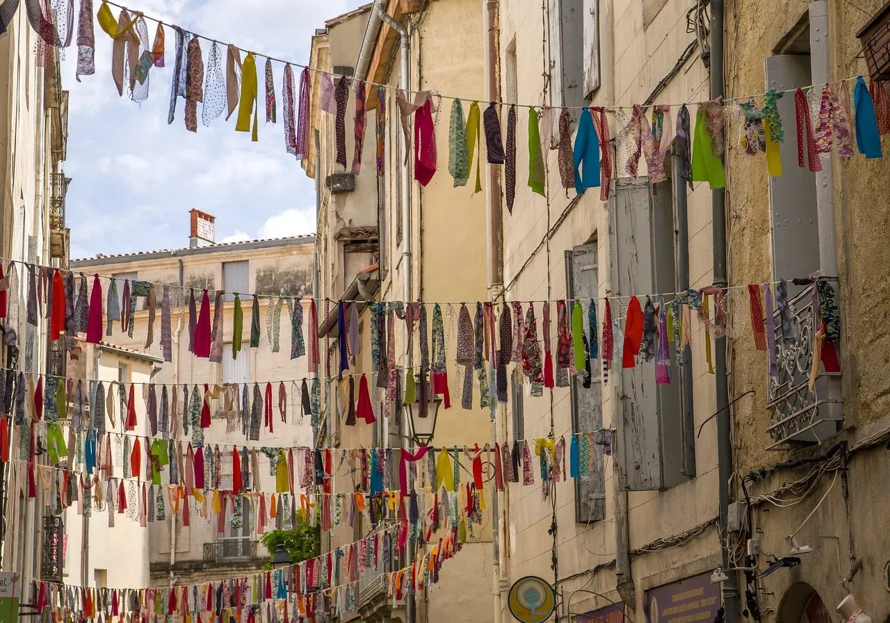 Ruelle pavée du centre historique de Montpellier ornée de guirlandes colorées